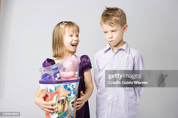children with a large cornet of cardboard filled with sweets and little presents given to children in germany on their first day at school - brother jealous stock pictures, royalty-free photos & images