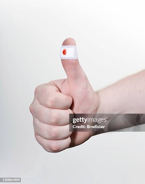 thumbs up with a plaster with a blood stain, wound - bandaged thumb stock pictures, royalty-free photos & images