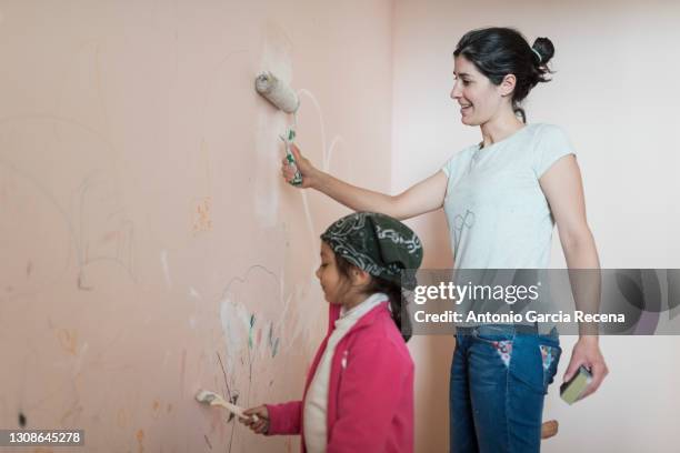 mother and daughter painting at home with white paint - school reform stock pictures, royalty-free photos & images
