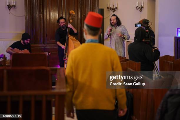 Member of the Fraenkelufer Synagogue Jewish community wears a fez hat for fun while watching the Berlin-based Sistanagila band of Israeli and Iranian...