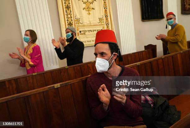 Members of the Fraenkelufer Synagogue Jewish community applaude while listening to the music of the Berlin-based Sistanagila band of Israeli and...