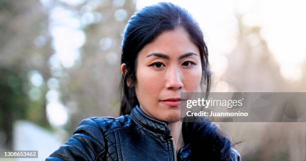 very concerned pensive serious unemployed asian mid adult woman looking at the camera - 35 female outdoors stock pictures, royalty-free photos & images