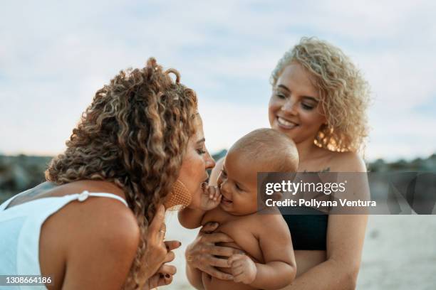 madre y abuela jugando con el niño en la playa - mothers day beach fotografías e imágenes de stock