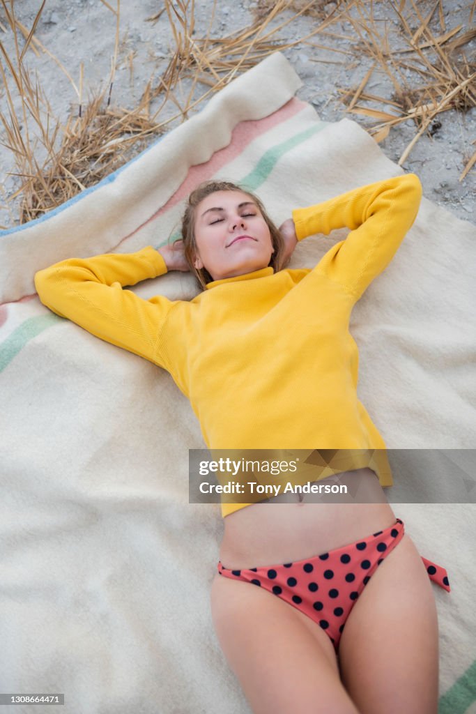 Young woman lying blanket at beach