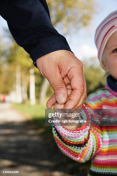 father and his three-year-old daughter holding hands - 2 year old blonde girl father stock-fotos und bilder