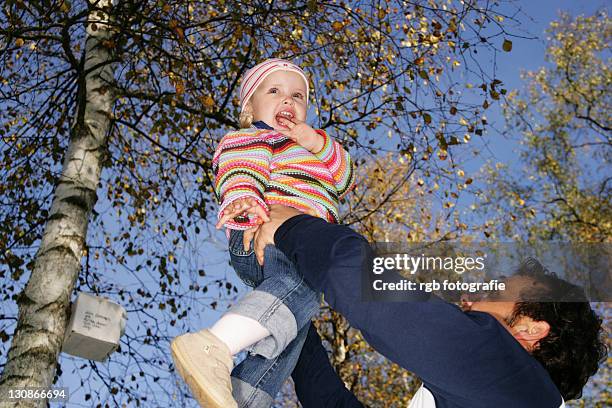 father holding his three-year-old daughter in the air - 2 year old blonde girl father ストックフォトと画像