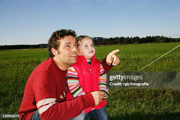 father and his three-year-old daughter playing with a kite - 2 year old blonde girl father ストックフォトと画像