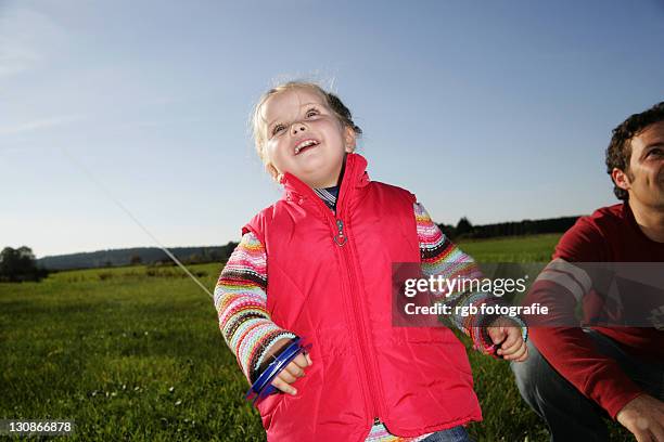 father and his three-year-old daughter playing with a kite - 2 year old blonde girl father ストックフォトと画像
