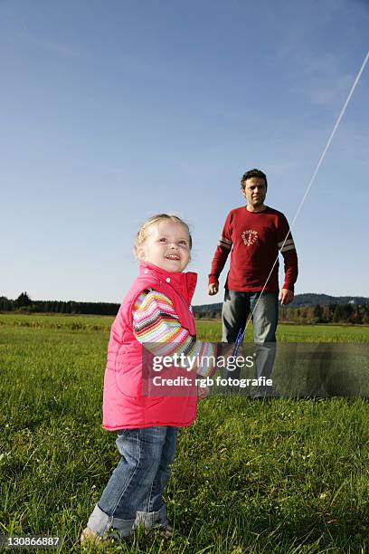father and his three-year-old daughter flying a kite - 2 year old blonde girl father ストックフォトと画像