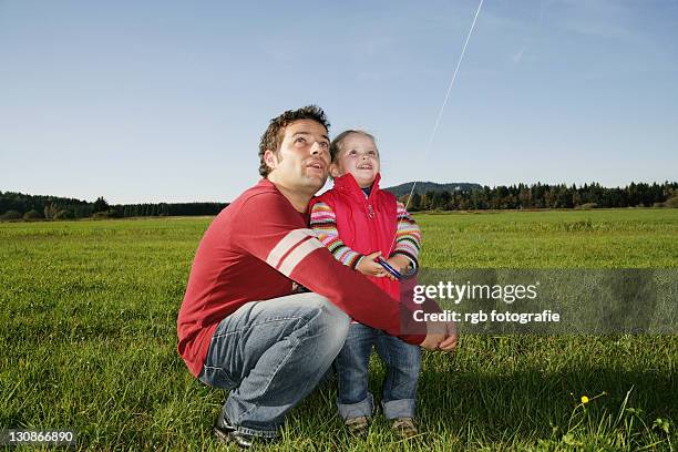 father and his three-year-old daughter flying a kite - 2 year old blonde girl father ストックフォトと画像