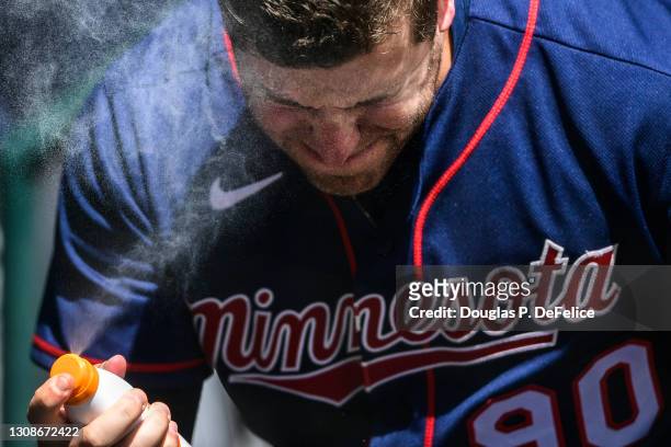 Caleb Hamilton of the Minnesota Twins sprays sunscreen on his face prior to the game between the Minnesota Twins and the Pittsburgh Pirates during a...