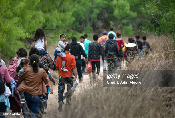 Asylum seekers, most from Honduras, walk towards a U.S. Border Patrol checkpoint after crossing the Rio Grande from Mexico on March 23, 2021 near...