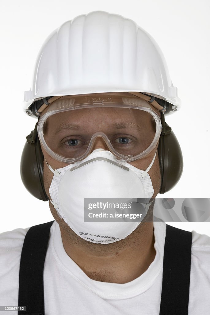 Craftsman with protective goggles, face mask, ear protection and helmet