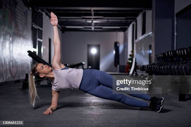 beautiful young woman doing side plank pose in the gym - side plank pose stock pictures, royalty-free photos & images
