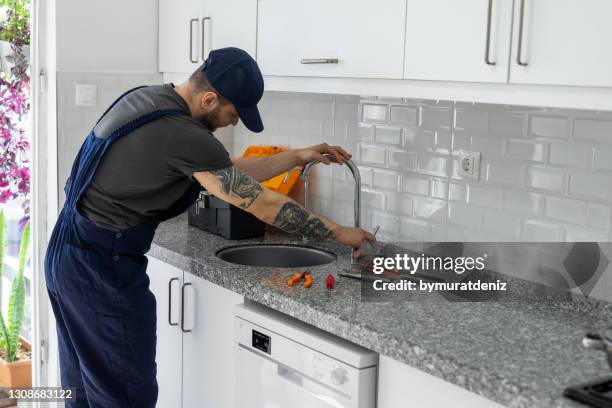 man's hands working on a kitchen sink - kitchen straighten stock pictures, royalty-free photos & images