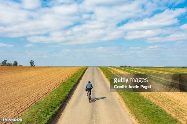 cyclist on road in countryside - uphill stockfoto's en -beelden