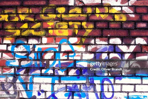 graffiti on a brick wall - graffiti on brick wall stock-fotos und bilder