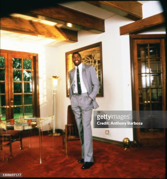 Portrait of American basketball player Magic Johnson as he poses in his home, Los Angeles, California, 1980s.