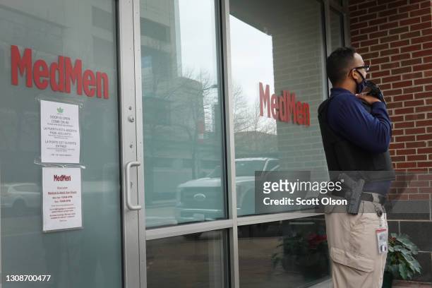 Security worker stands in front of the MedMen marijuana dispensary on March 23, 2021 in Evanston, Illinois. The City Council of Evanston voted...
