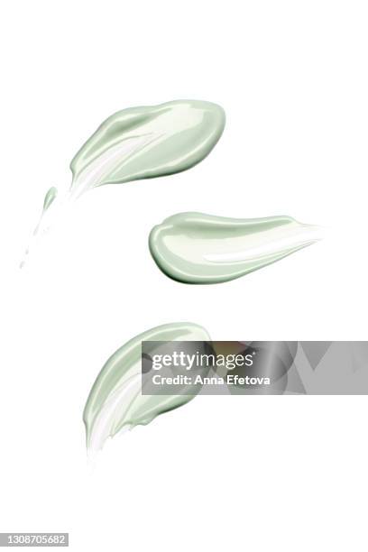 group of textured cosmetic smears of pastel green cream isolated on white background. concept of health and wellbeing. flat lay style with copy space - body paint art fotografías e imágenes de stock
