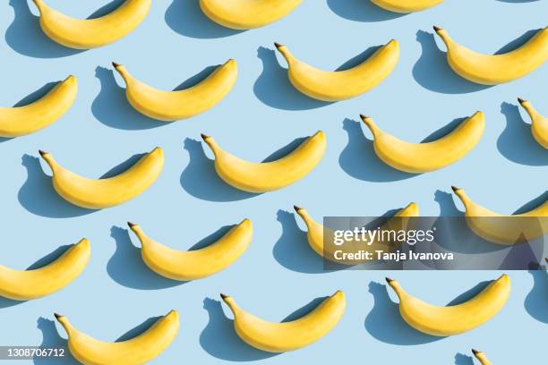 colorful fruit pattern of fresh yellow bananas on blue background with shadows. fruit concept. flat lay, top view. - バナナ ストックフォトと画像