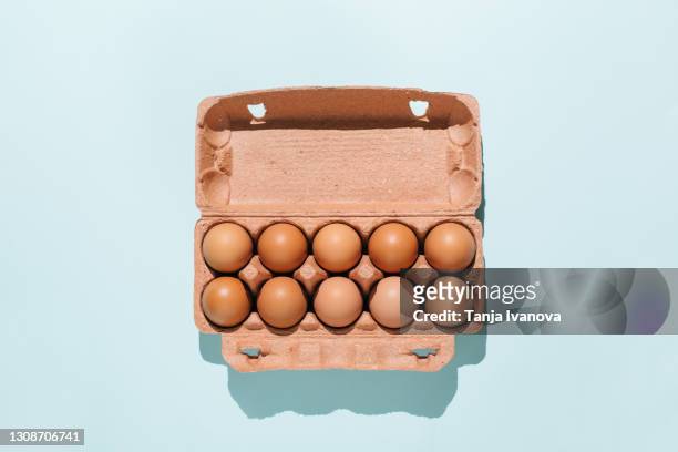 organic eggs in cartons tray on blue background. flat lay, top view - easter egg stock pictures, royalty-free photos & images