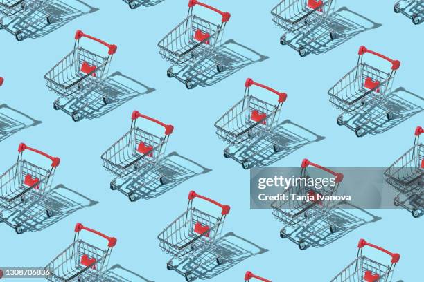 pattern made of shopping trolley on blue background. shopping and sale concept. flat lay, top view - wagon foto e immagini stock