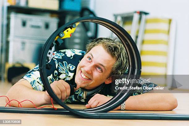 young man playing with toy car speedway - toy car loop stock pictures, royalty-free photos & images