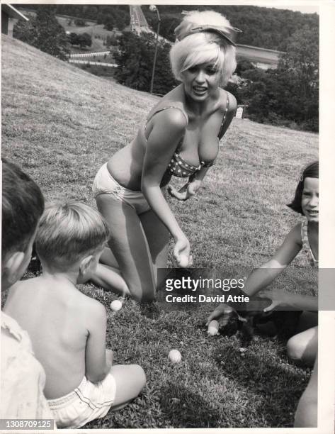 Actress and model Jayne Mansfield poses for a portrait while playing on the grass with children in 1964 in New York City, New York. Taken for the...