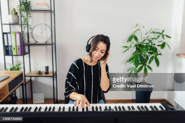 portrait of young beautiful woman creating music at home. - pianist stock pictures, royalty-free photos & images