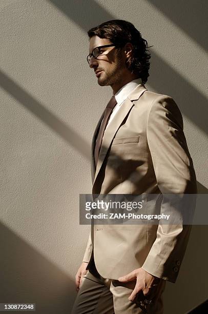 fashion shoot, a man wearing glasses and a suit in the sunlight - bruin pak stockfoto's en -beelden