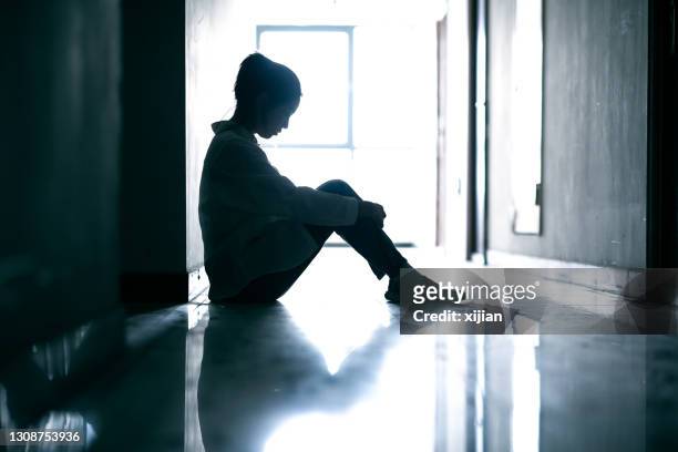 depressed teenage girls sitting on corridor ground - worry free stock pictures, royalty-free photos & images
