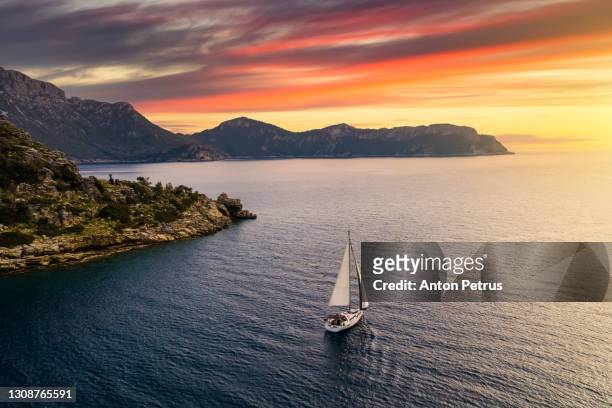 yacht near the rocky coast in turkey at sunset. yachting, luxury vacation at sea - rijkdom boot stockfoto's en -beelden