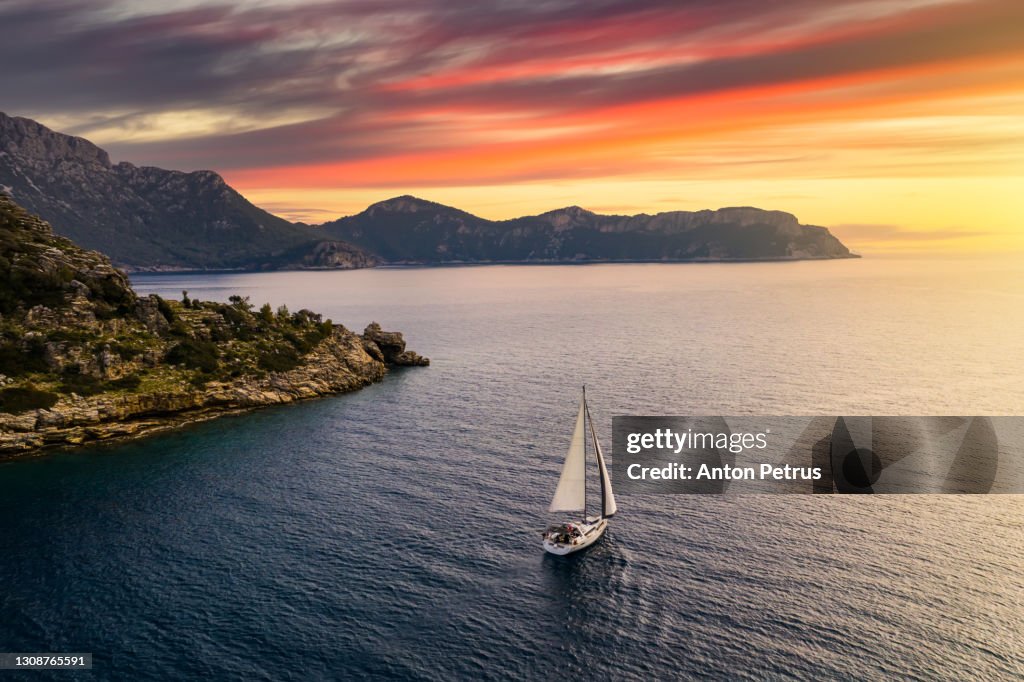 Yacht near the rocky coast in Turkey at sunset. Yachting, luxury vacation at sea