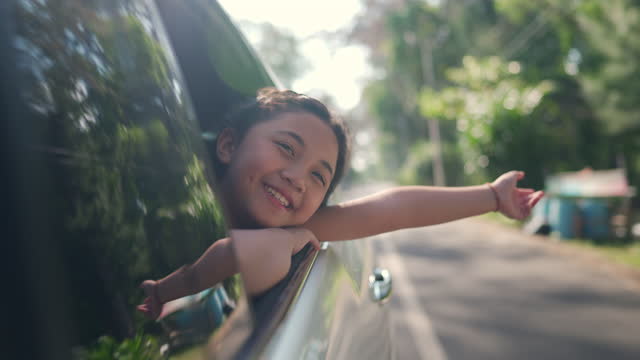 4K Happy little Asian girl enjoy and having fun with parents in the car on road trip vacation.