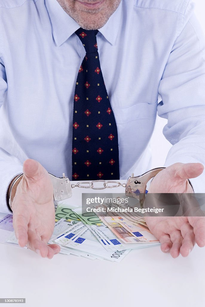 Businessman in handcuffs, symbolic picture for business crime