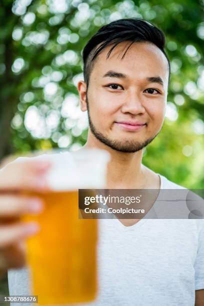 young man drinking beer - biergarten stock-fotos und bilder