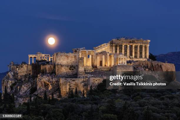 moon rising behind the acropolis - ancient greece photos stock-fotos und bilder