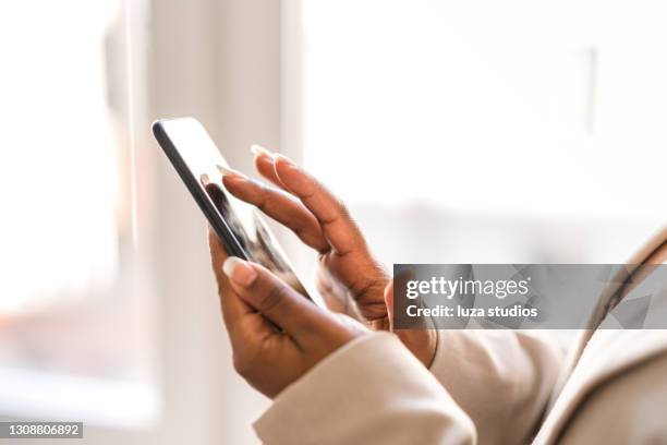 woman working from home using her smartphone - high key stock pictures, royalty-free photos & images