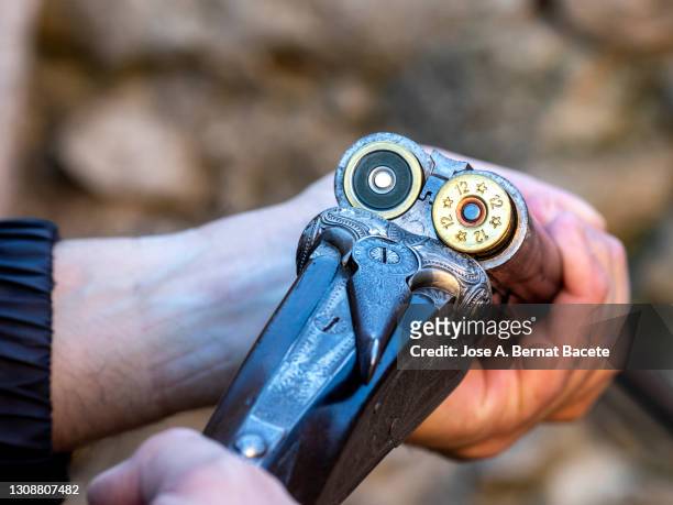 hands of a hunter with an open shotgun ejecting the cartridge during a hunting day. - shotgun stock pictures, royalty-free photos & images