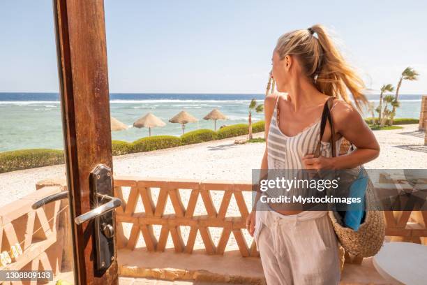 donna contempla la vista sul mare dal suo balcone - beach bag foto e immagini stock