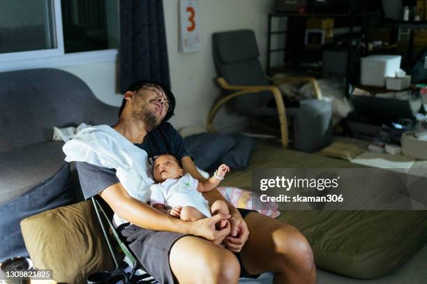 young adult  asian father sleepy and holding his baby daughter on his chest and baby wake up in the night times - moms crying in bed stockfoto's en -beelden