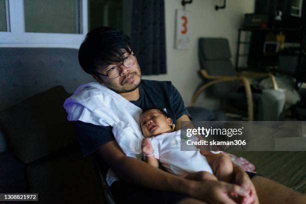young adult  asian father sleepy and holding his baby daughter on his chest and baby wake up in the night times - moms crying in bed stock pictures, royalty-free photos & images