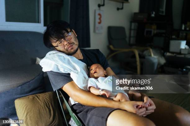 asian father sleepy and holding daughter and daughter wake up in the night time - mum dad and baby fotografías e imágenes de stock