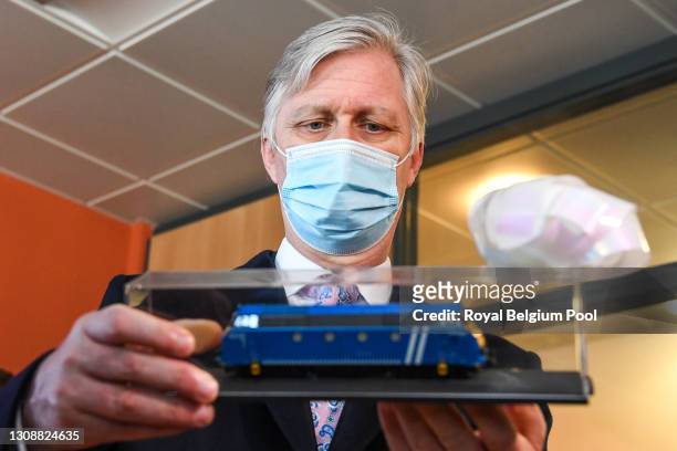 King Philippe of Belgium looks at a miniature toy train during his visit to the train-station Ottignies on March 24, 2021 in Ottignies-Louvain-la...