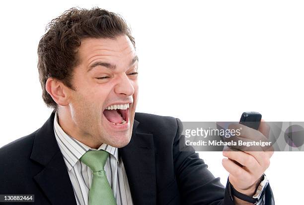 businessman screaming with mobile phone - fast furious stock pictures, royalty-free photos & images