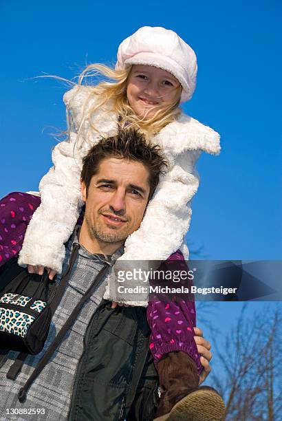 father carrying his 7-year-old daughter on his shoulders - 2 year old blonde girl father stock-fotos und bilder