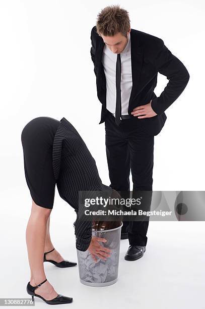 businesswoman watching businesswoman sticking her head in a bin - full height stock pictures, royalty-free photos & images