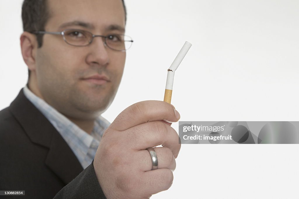 Man holding broken cigarette: smoking cessation