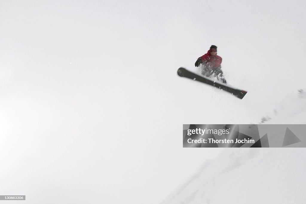 Jumping snowboarder at a snowy day in Saalbach Austria